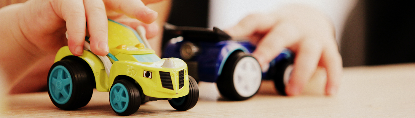 Kind spielt mit zwei Autos