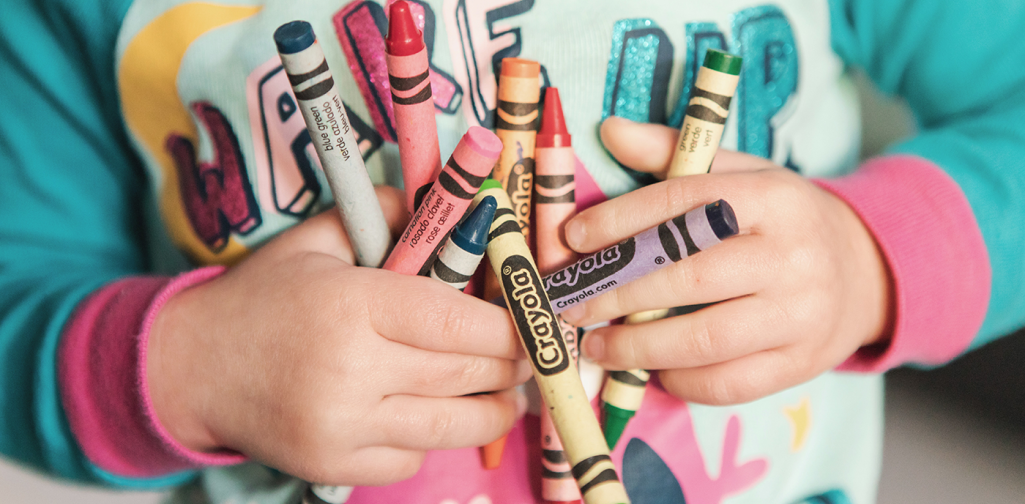 Kind mit Wachsmalstiften